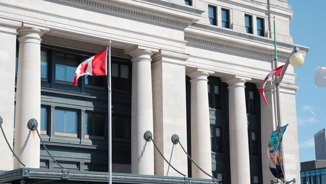 Senate of Canada building with Canadian flags on a sunny summer day in Ottawa, Canada - 4K slow motion