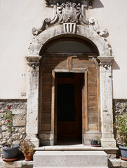 Fototapeta na wymiar Pescocostanzo , Abruzzo: Entrance door with magnificent ancient stone portal and the coat of arms of the family