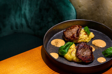 Grilled pieces of meat with mashed potatoes, basil and sauce