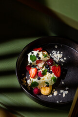 Cake with almond slices, strawberries, raspberries, mint and sauce