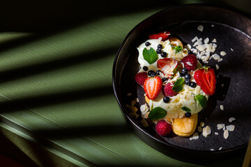 Cake with almond slices, strawberries, raspberries, mint and sauce
