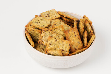 Homemade diet cookies with herbs, flax seeds  and spices on white. Herbal crunchy crackers isolated