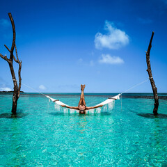 Beautiful sexy tanned woman in white bikini on Maldives island. Young glamour girl is posing on...
