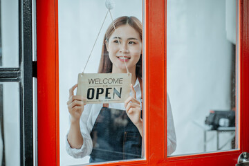 Back view glass door small business owner holding a sign to open a shop