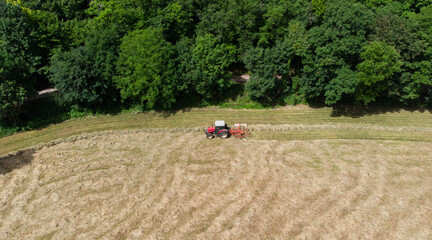 Passage d'un tracteur après le fauchage pour pratiquer l'andain. Cadre naturel en bordure de pré...