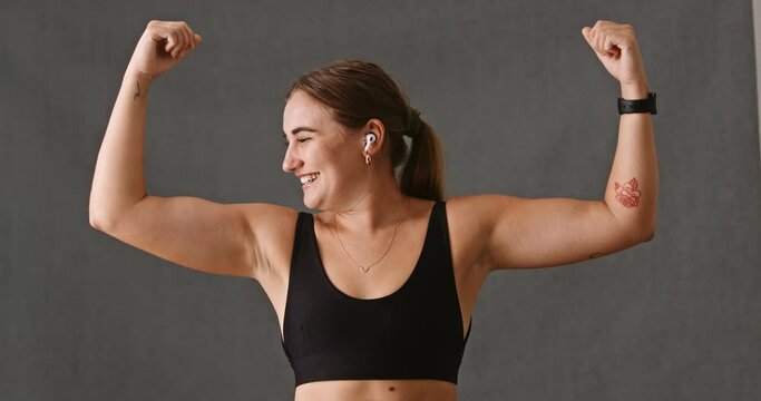 Young Caucasian woman doing arm flexing and loving it 