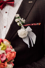 White beautiful boutonniere on the groom's jacket
