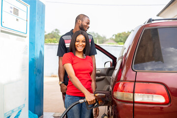 Pumping gas at gas pump.black Woman refuel the car. Woman at the petrol station.