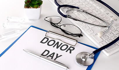 DONOR DAY text on white paper on white background. stethoscope ,glasses and keyboard