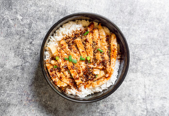 Top view grilled chicken with spicy sauce on rice.