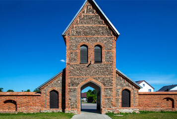 Fototapeta na wymiar St. Lawrence, erected in the Gothic style with a defensive wall in 1518 in Kleczków in Masovia, Poland. General view and details of the construction of the temple and wall at the photo.
