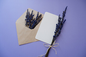 Blue lavender flowers and blanks message card on purple background. Summer greeting concept flat...