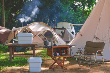 Foto op Plexiglas Outdoor kitchen equipment and wooden table set with field tents group in camping area of natural parkland at morning time © Prapat