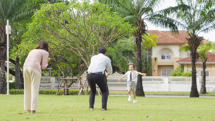 Portrait of happy smiling Asian Family walking together in public garden park in family relationship on vacation. Love of father, mother, and son. People lifestyle.