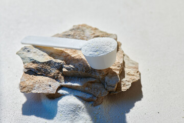 Sport food supplement powder with natural beige background and props. Supplement, creatine, hmb, bcaa, amino acid or vitamine in a white scoop. Sport nutrition healthy life→ Check my profile for more!