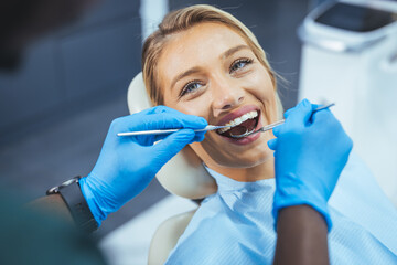 Closeup shot professional dentist with protective surgical mask, doing check up of patient. Dentist...