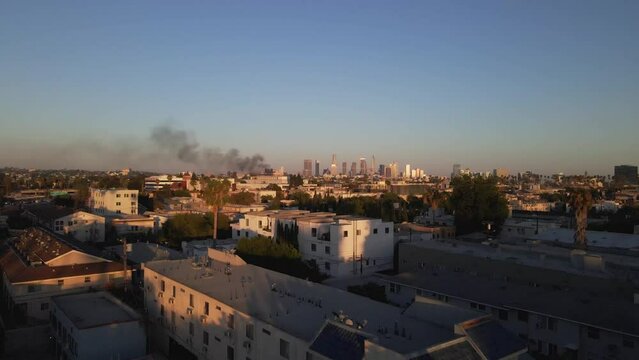 Aerial shot of smoke and Los Angeles skyline during summer afternoon in 4k, push in. 