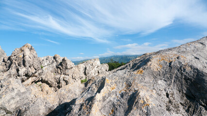 Rocas graniticas con manchas de liquen amarillo en el litoral bajo cielo azul