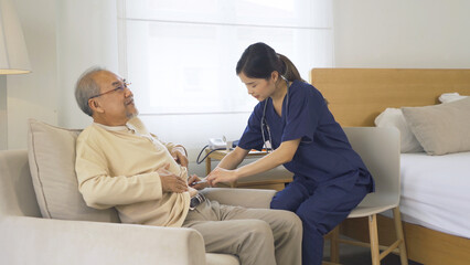 Obraz premium Happy woman nurse, daughter check up body of sick old senior elderly patient lying on bed in bedroom in home or house in medical and healthcare treatment. Asian Thai people lifestyle. Family