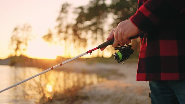 Fisherman Is Catching Fish Alone In Sunset Or Sunrise, Closeup Of Fishing Rod In Hands, Calm And Active Rest In Nature