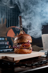 Meat burger in smoke with knife