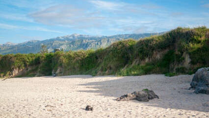 Cordillera montañosa en el horizonte de una playa rocosa