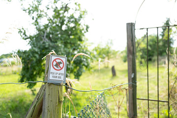 Generic dog poop sign seen at the entrance to a public allotment area. Notice the garden gate used...