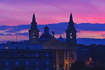View of the facade of St. Publius Parish Church against the sunset sky in Floriana