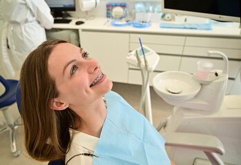 Woman having dental procedure in clinic. Concept of dentistry and orthodontic treatment.