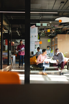 Multiracial creative businessman and businesswoman discussing business ideas in office