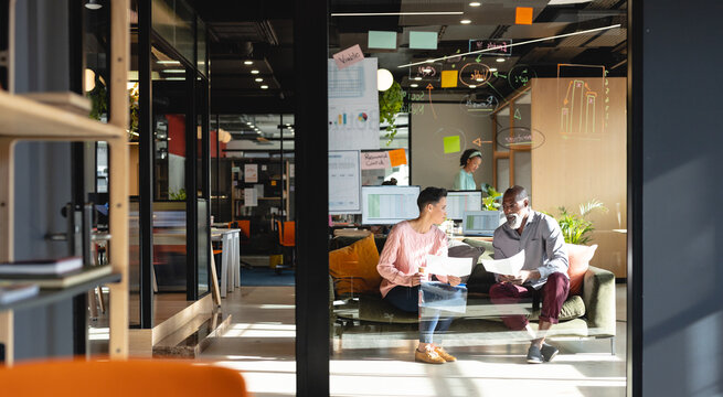 Multiracial creative businessman and businesswoman discussing business strategy in office