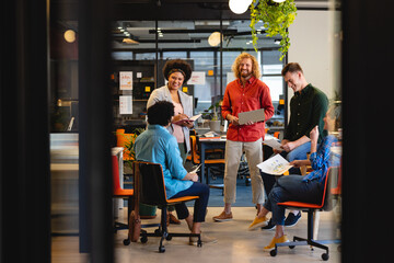 Multiracial creative businessmen and businesswomen discussing during meeting in office