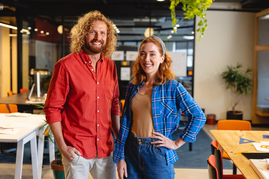 Portrait of smiling caucasian young male and female architects in office
