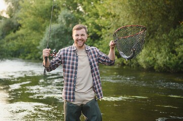 Fly-fisherman holding trout out of the water - Powered by Adobe