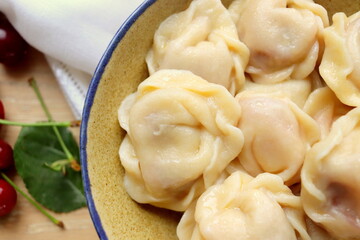 delicious sweet dumplings with cherries in a clay plate close-up on the table selective focus