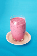 Fresh and delicious drink full of vitamins and antioxidants based on mixed red fruits in a tall glass on a blue background.
Red fruit smoothie in glass. Copy space.