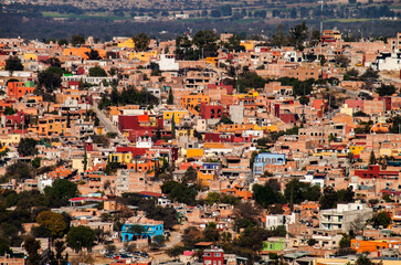 Panoramic urban landscape, the historical old town of San Miguel de Allende, Guanajuato, Mexico. Colorful, traditional colonial downtown neighborhood houses. Mexican architecture, rooftops, townscape.