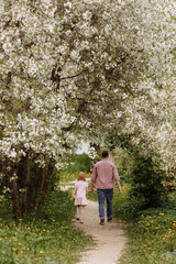 Father and little daughter are walking.