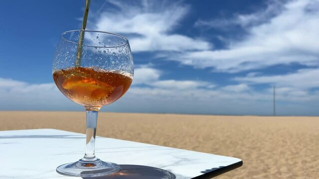 In a glass pour iced tea or whiskey in the background of the ocean or sea blue sky occupies the entire space. lovely background for advertising and there is space for text High quality photo