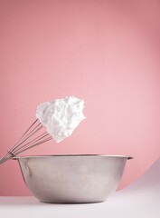 cream with a cooking bowl on pink background