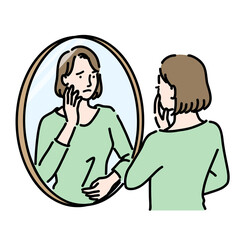 不安げに鏡を見ている女性
