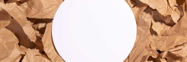 White empty blank circle mockup on multiple pieces of torn brown crumpled, wrinkled recycle craft paper background banner. Composition with copy space and place for text. Wide panoramic header