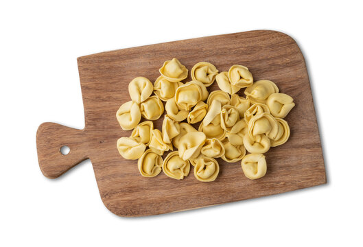 Uncooked cappelletti or tortellini on a board isolated over white background