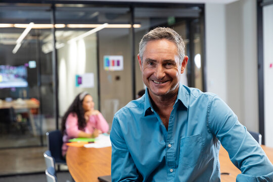 Portrait of smiling mature caucasian businessman in board room at office