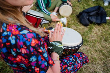 The girl drums on the djemba festival of music in nature, street musicians, play the percussion...