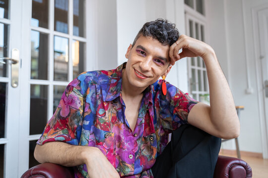 Confident Transgender Man In Casual Sitting On Sideboard