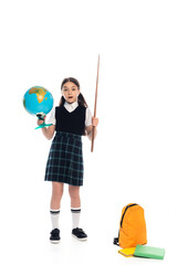 Shocked schoolgirl holding globe and pointer near backpack and books on white background.