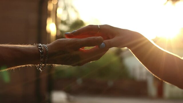 hands of romantic couple a close-up. hands men and women symbol love teamwork sunlight happy family together. silhouette hands support stroking each other. dating, romantic atmosphere.