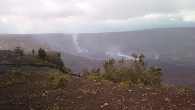Static close-up shot of of the smoking Kilauea cauldron in the fog and rain on the Big Island of Hawaii. 4K