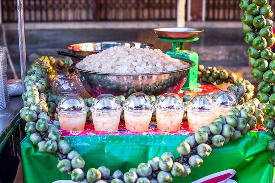 Seeds of sugar palm sold at Phuket night market, Thailand. Translucent Kolang kaling in large metal bowl selling on street, soft selective focus